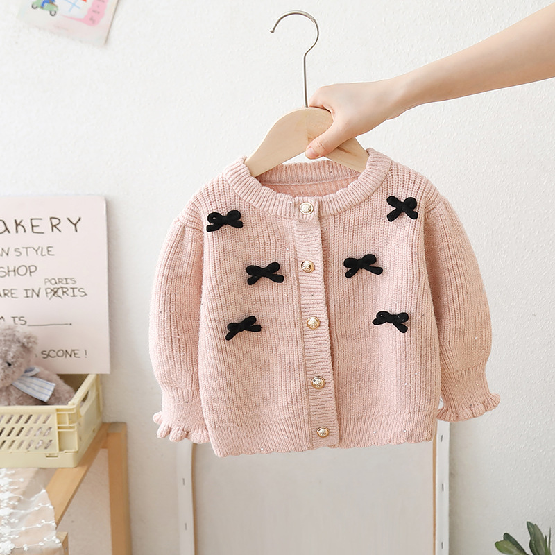 A woolen jacket adorned with a bow and in a solid color 