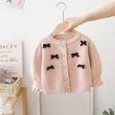A woolen jacket adorned with a bow and in a solid color 