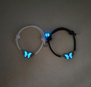 A luxurious jewelry set including a necklace and bracelet with a glowing blue butterfly design, illuminating in the dark for a captivating touch 