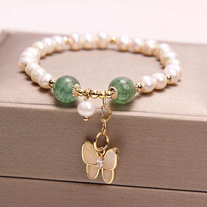 An elegant necklace featuring freshwater pearls and strawberry quartz, with an opal butterfly pendant, adding a touch of elegance and beauty to your look