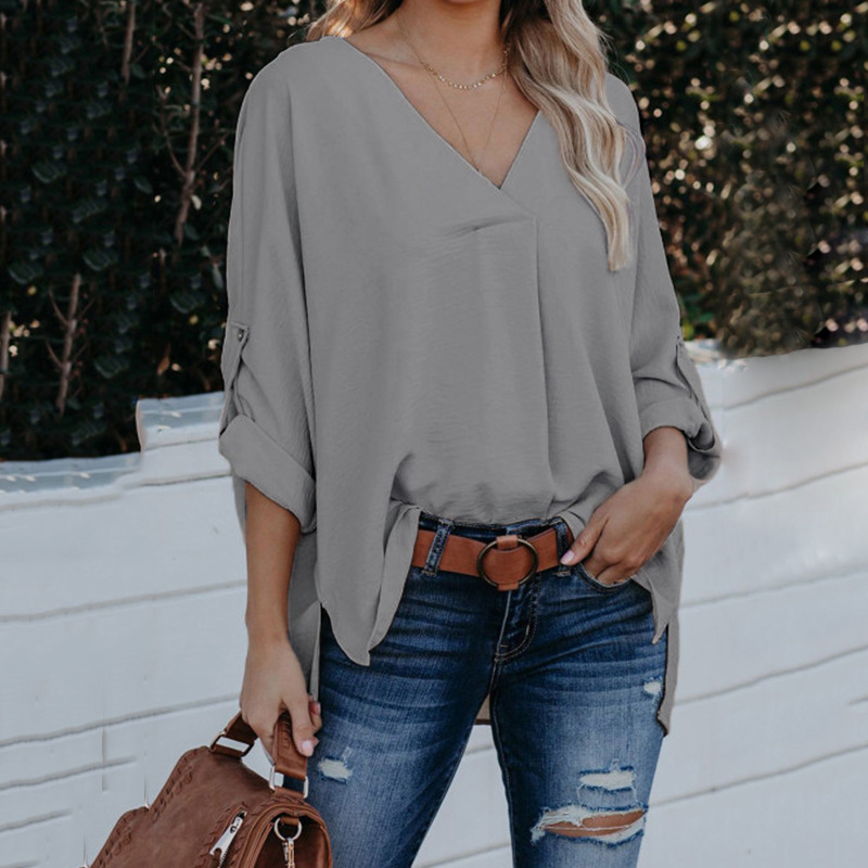 "Elegant women's loose-fit shirt with a modern cut, V-neckline, and long sleeves in a solid color."
