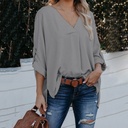 "Elegant women's loose-fit shirt with a modern cut, V-neckline, and long sleeves in a solid color."