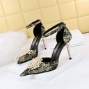 Low‑strap pointed stiletto embellished with rhinestones, pearls, and floral accents