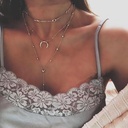 An elegant multilayer necklace featuring a crescent moon pendant and a bead chain, perfect for adding a touch to your look