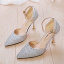 A high-heeled, pointed-toe shoe with a low-cut vamp and sparkling sequins